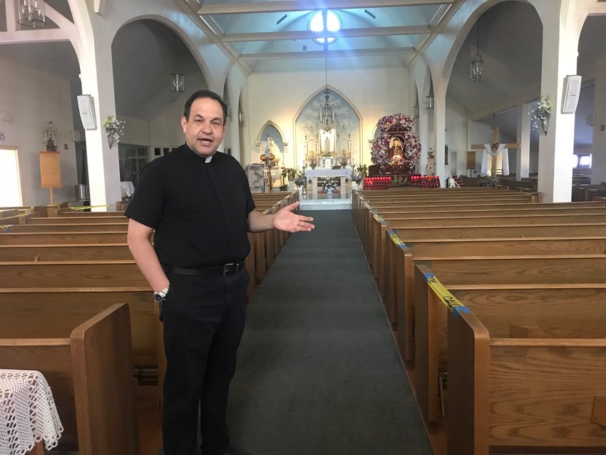 The Rev. Marinaldo Batista, in the inside of St. Elizabeth&rsquo;s Church, where they have taped off pews and made preparations to hold in-person Mass beginning May 31.