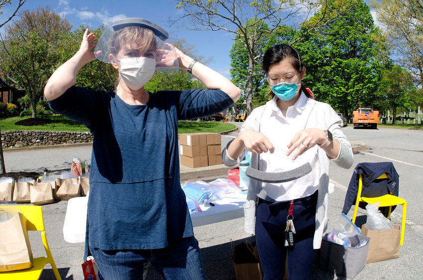 Dr. Lisa Denny of Barrington Family Medicine (left) and fourth-year Brown medical student Vivian Chan Li, of Central Falls, hand out face shields, masks and other various PPE to medical offices and nursing homes on Saturday behind the Barrington Town Hall.