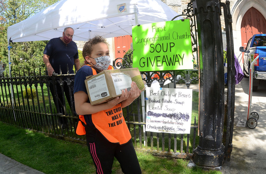 Rosalee Bagby-Grose, 10, from the First Congregational Church, carries a box of Blount lentil soups to a vehicle pulled up along High Street during the church&rsquo;s soup giveaway on Tuesday.
