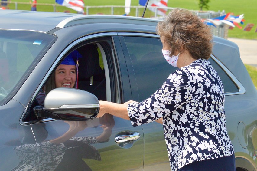 Graduating senior Mackenzie Gill greets School Committee Chairwoman Emily Copeland as she receives her diploma Saturday morning at Portsmouth High School.
