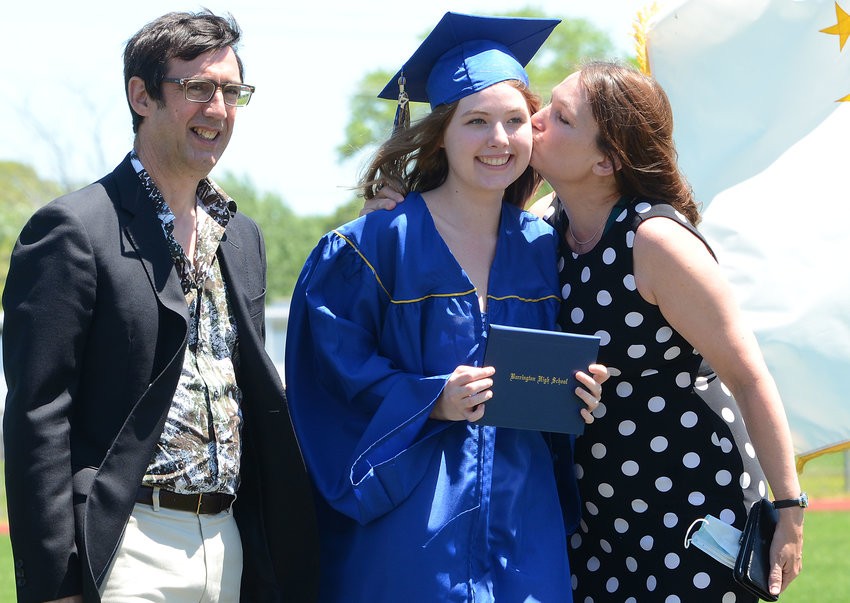 Grad Kate Demeillon gets a kiss from mom, Imogene as dad, Ian looks on.