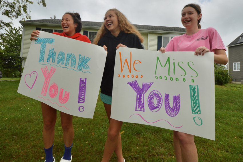 Olivia Durant, Ava Moore and Emma Sherrod (from left), all eighth-graders at Portsmouth Middle School, show their support to faculty members during Portsmouth Middle School&rsquo;s parade for eighth-grade students Friday morning. They were gathered on Mailcoach Road in the Redwood Farms neighborhood.