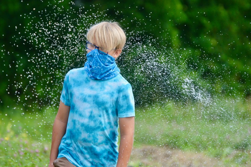 Aurelius Brockman, a sixth-grader at Portsmouth Middle School, briefly pauses from his task of moving sprinklers around a student garden at Cloverbud Ranch to get some welcome relief from the stifling heat morning Monday.