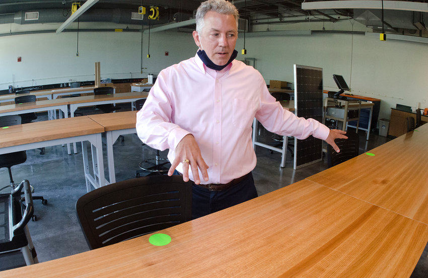Standing in an engineering lab, Roger Williams University Chief of Staff Brian Williams explains how students and professors will be responsible for cleaning surfaces after their class. The green dots indicate desks that are open for us, while red dots indicate they are closed. The dot system is designed to enforce social distancing as the campus returns to mostly normal activity.