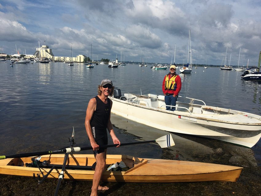 Rock Singewald poses by his kayak at the completion of his 25-mile row to Newport, with Curtis Betts in the background.