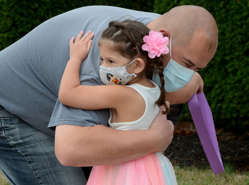Chris Deltoro gives his daughter, Bella, a hug before she heads into class at Sowams School.