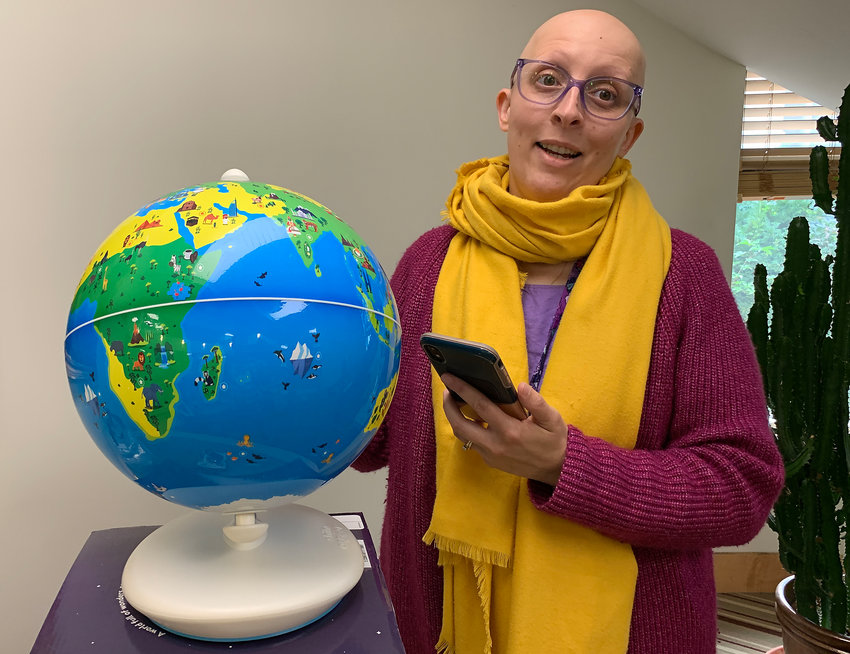 Kristin Amaral shows off Rogers Free Library&rsquo;s new augmented reality globe, which works with a phone app and lets users learn about various cities and countries when they point to a location on the sphere.