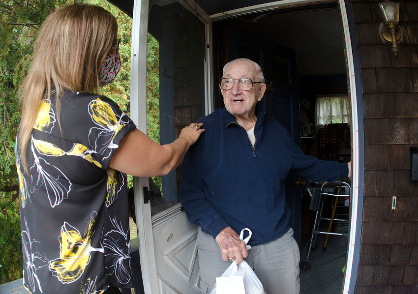 Donna Wilson of the Bristol Senior Center delivers lunch on Tuesday, Sept. 19, to Frank Palumbo. For many Bristol seniors isolating during the pandemic, a brief interaction like this might be the only contact with another person they have all day.