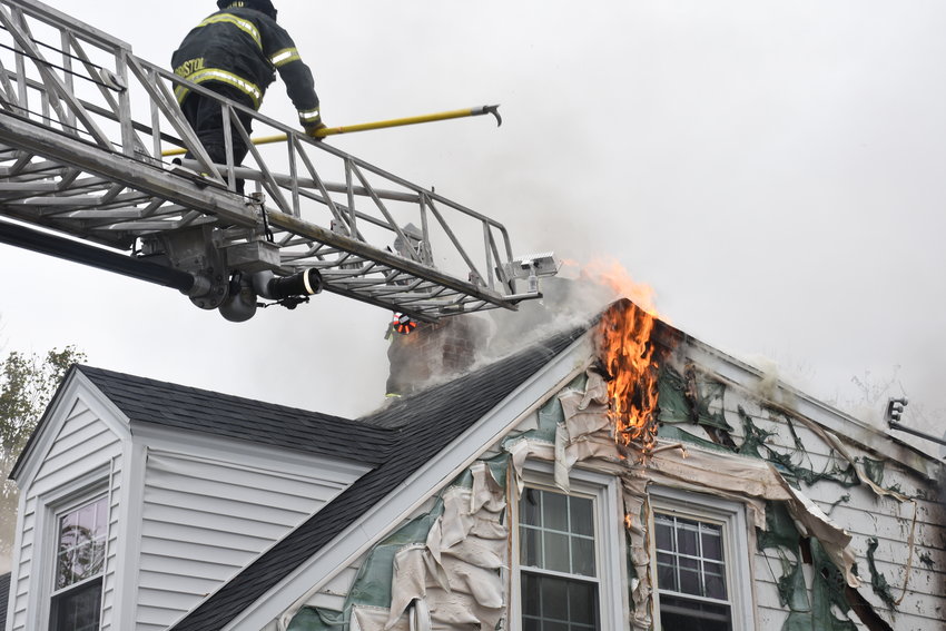 Firefighters used the ladder truck to get at the flames that were spreading into the upper levels of the house on Colonial Road.
