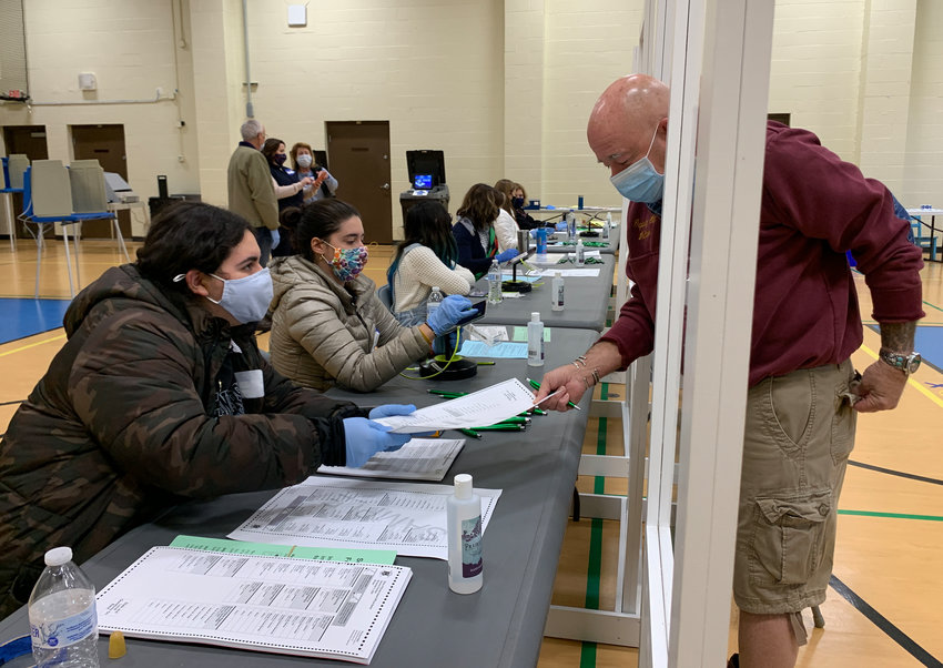 Election officials Rowanne Curran (left) and Bethany Marshall sign in Bristol resident&nbsp;Paul Vollaro at the Quinta-Gamelin Community Center on Tuesday.&nbsp;