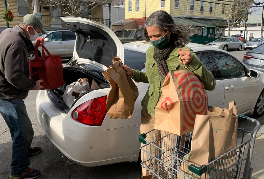 East Bay Food Pantry volunteer Joe Sullivan (left) and Executive Director Karen Griffith put food bags into a client&rsquo;s car on Wood Street on Wednesday morning.