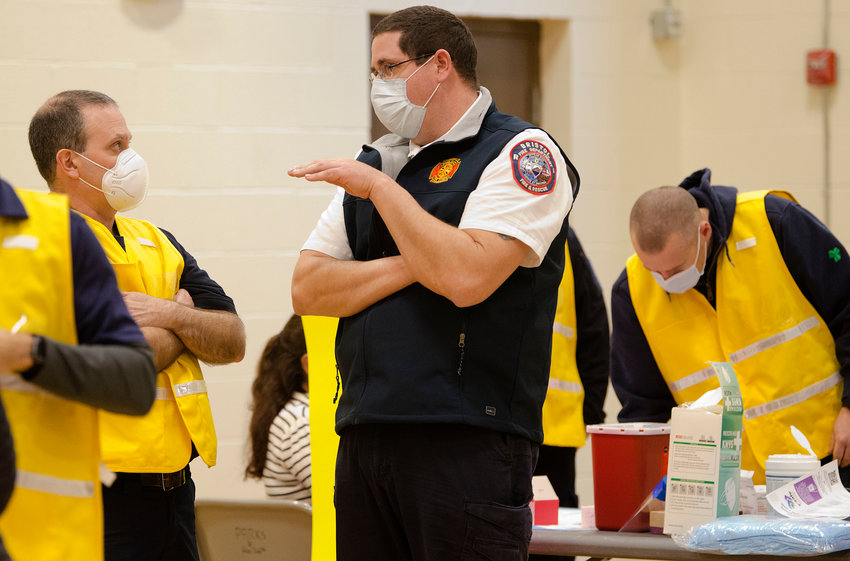 Bristol Fire Chief Michel DeMello&nbsp;gives instruction to&nbsp;EMS volunteers as the first day of vaccinations comes to an end back in December. Chief DeMello and Bristol Police Lt. Steven St. Pierre led an enormous team of town employees and volunteers in ramping up and executing vaccine distribution and testing centers for months.