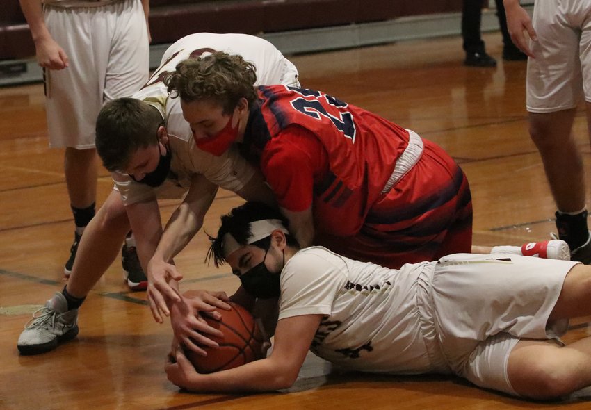 Sophomore forward Jason Potvin (left) reaches in as teammate, Junior guard Luke Deldeo grabs a loose ball on the floor in the defensive court.&nbsp;