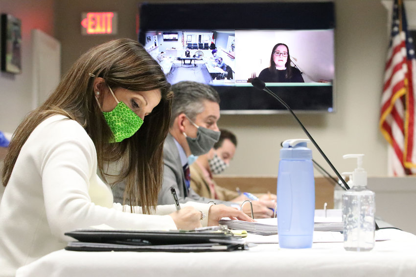 Town Clerk Melissa Cordeiro (foreground) takes notes as Susan Battle speaks to the Bristol Town Council, via Zoom on screen, as they discuss this year&rsquo;s budget at town hall last Thursday night.