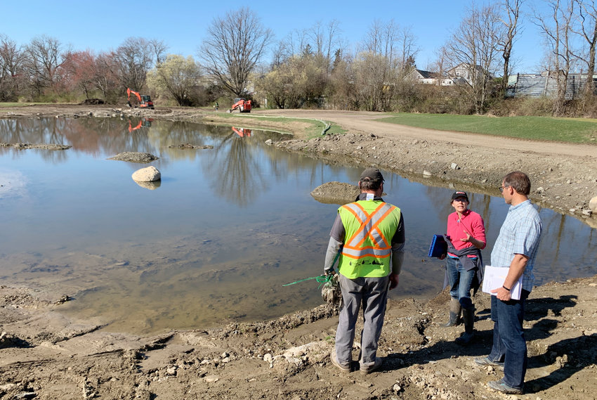 Wenley Furgeson (center), director of habitat restoration at Save the Bay,&nbsp;discuss plans for a pond on the new golf course with landscape architect Tim Gerrish (right) and a project manager.&nbsp;