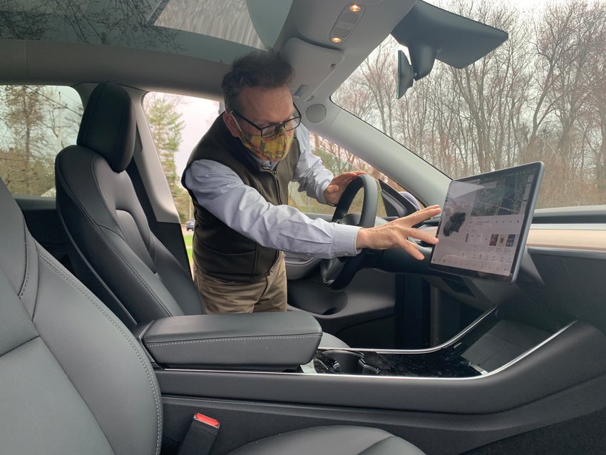 Magnus Thorsson shows off the interior of his Tesla. He said the town would save money by switching over the police department cruisers to Teslas.