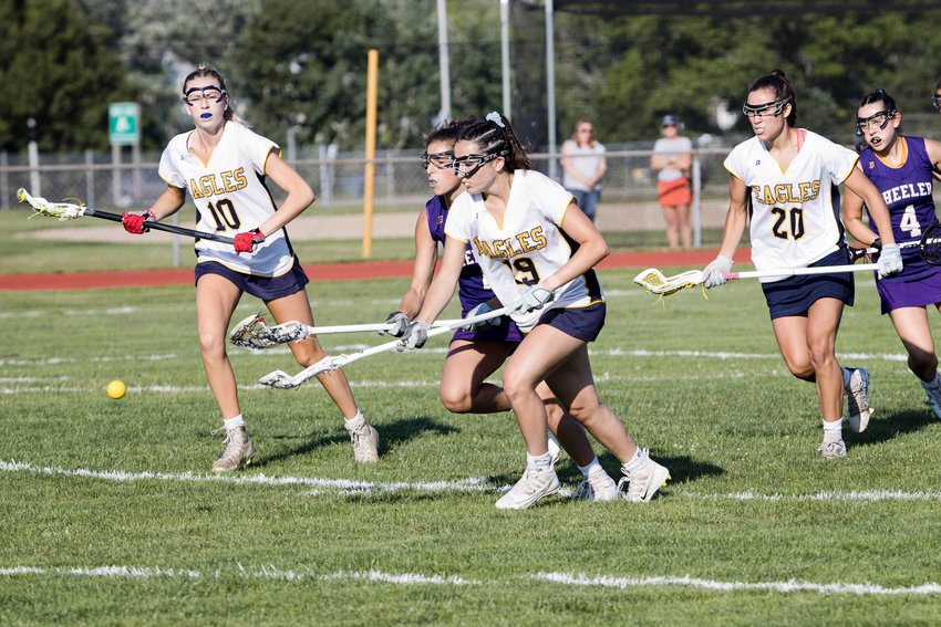 Kate Robertson, Ava Kovolyan, and Tess Gagliano (from left to right) race a Wheeler opponent to a loose ball.