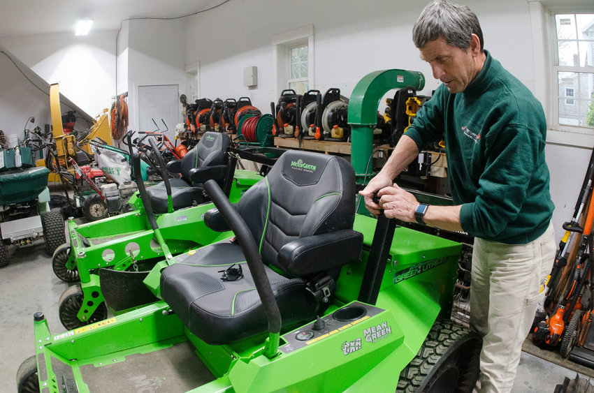 Tim Palmer in the garage with one of his Mean Green electric riding mowers.