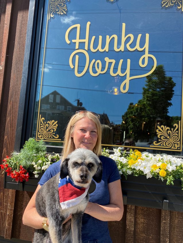 Kerri Payne of Residential Properties, along with her dog Penelope, pose in front of Hunky Dory in downtown Warren, one of the participating businesses of the Dog Stroll.