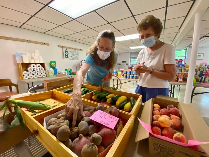 Volunteers Holly Billings (left) and Helen Pereira inspect some of the fresh local produce available this past Saturday at the Little Compton Food Bank