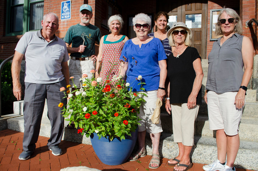 A handful of the Warren volunteer gardeners in front of Warren Town Hall, from left, Dave Frerichs, Keith Daniel, Elizabeth O&rsquo;Connell, Geri Herreid, Jane Swift, Paulette Clemens and Dottie Dylag in 2021 after planting zinnia and verbena in the pot in front of Town Hall. Without some help, there will be far fewer blue pots around downtown.