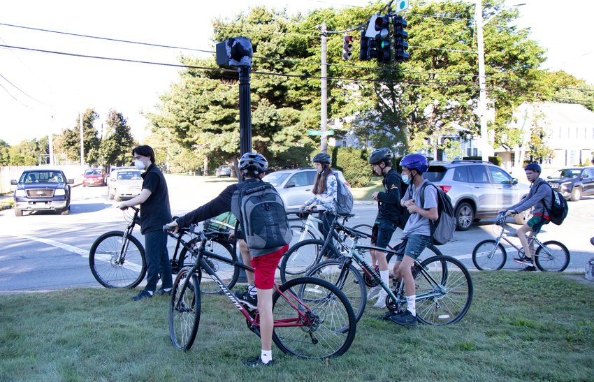 Barrington students wait at the intersection of County Road and Federal Road during the morning commute on Monday. Some parents are concerned about the district&rsquo;s decision to eliminate some bus stops and strictly enforce the two-mile ridership eligibility rule.