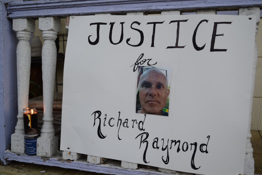 A sign displayed at a vigil held on Oct. 12 by family and friends of Richard Raymond, who was assaulted during an incident on Market Street in late August of 2021.