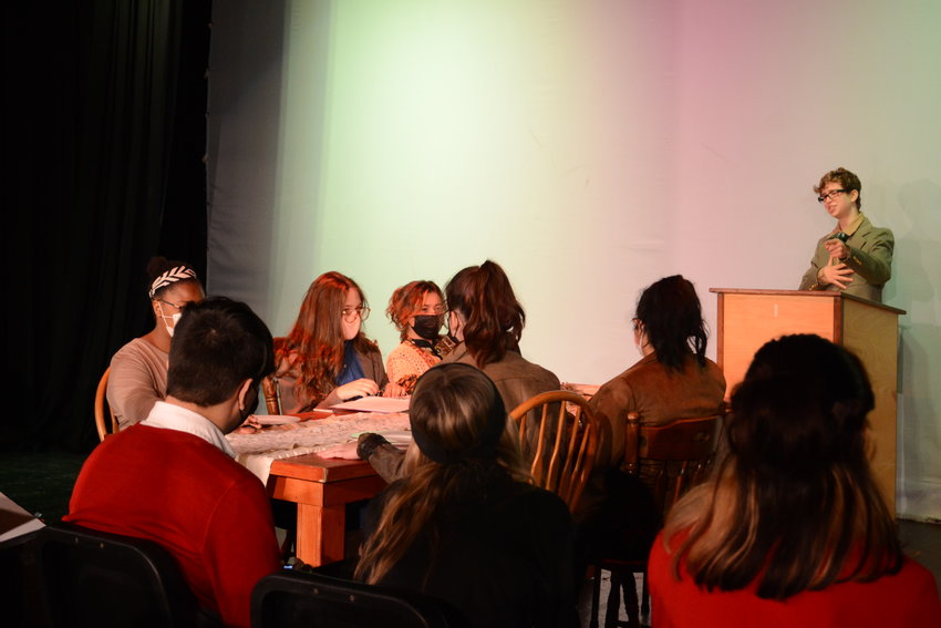 Liam Reich leads a family &lsquo;press conference&rsquo; at Thanksgiving dinner during &lsquo;Talking Points,&rsquo; which features fellow students Arabella Pichette, Seren Davies, Amani Jackson, Mariah Rogers, and Mia Shaw. It was part of the theater students' Fall Play in 2021.