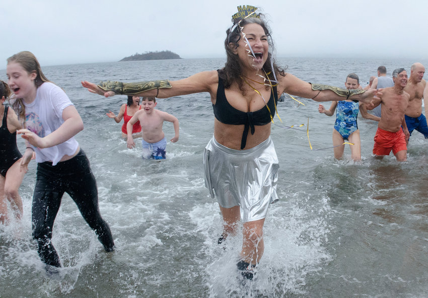 Tiverton resident Gloria Crist, channeling her inner Isis and Athena, runs from the ocean during Tiverton Yacht Club's Polar Plunge at Grinnell's Beach on Saturday at noon.
