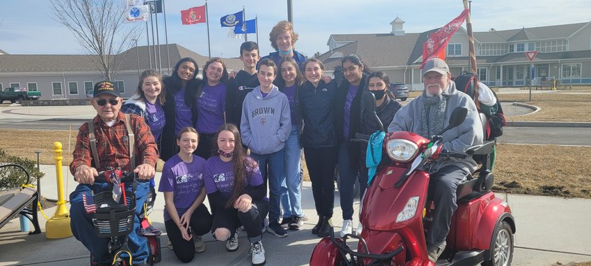This year&rsquo;s Solve for Tomorrow team, flanked by R.I. Veterans Home Residents Frank Silvia (left) and Steven Coyne, include (front row, l-r) seniors Alice Grantham and Mikayla Hudon; and (back row, l-r) seniors Mikayla Ricks, Aditi Mehta, and Abby Heroux, freshmen Jacob Betres and Luke Daniel, junior Henry Scott, and freshmen Eliza White, Lucy O&rsquo;Brien, Zahra Sheikh, and Madeline St. Pierre. Photo Courtesy of Mary Cabral.