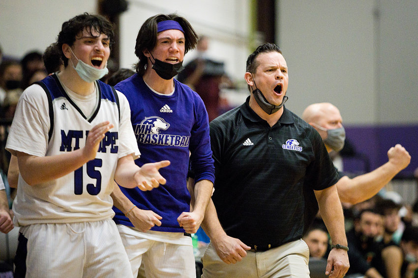 Head coach, Jeff Grifka (right) cheers with his team after the Huskies carry out a successful play.