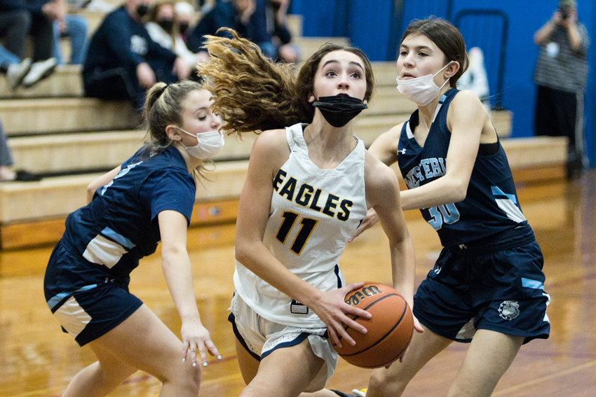 Liv Morrissette splits a pair of Westerly opponents while driving the ball toward the hoop.