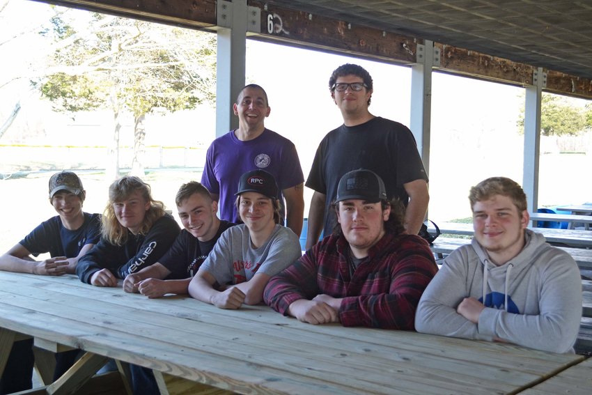 Students from various levels of Ryan Garrity&rsquo;s (standing, to the left) construction program sit at one of the two handicap-accessible picnic tables that they built for the Town of Warren&rsquo;s Pete Sepe Pavillion. Sitting (not listed in order), they include: Tyler Gow, Sam Rodrigues, Gavin Akervik, Jared Hughes, Zachary Janke, and Nate Evans. Standing next to Garrity is senior Aidan Lima.