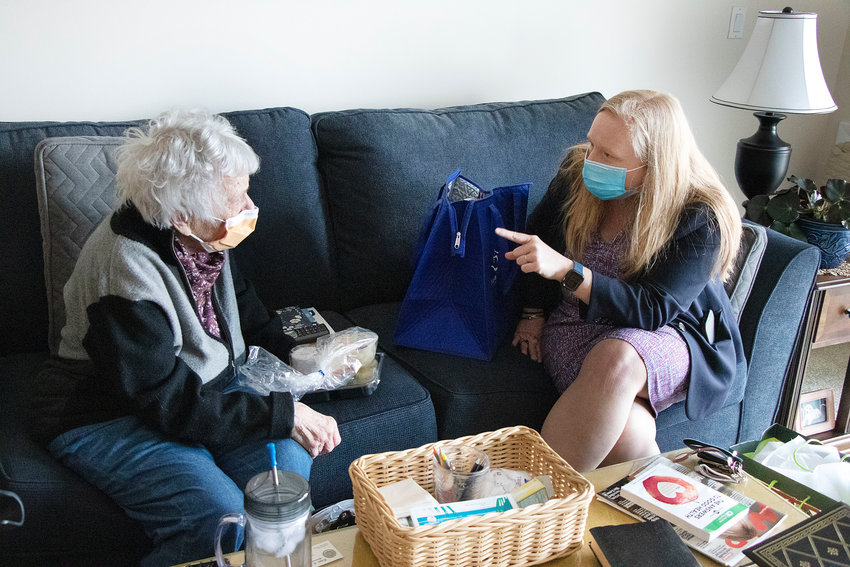 Helen Spets (left), a 95-year-old resident of Bay View Estates, chats with R.I. Meals on Wheels Executive Director Meghan Grady during a visit to her apartment on March 15. Town Council Vice President Linda Ujifusa also helped deliver a meal of shepherd&rsquo;s pie, plus a blanket, slippers and a puzzle.