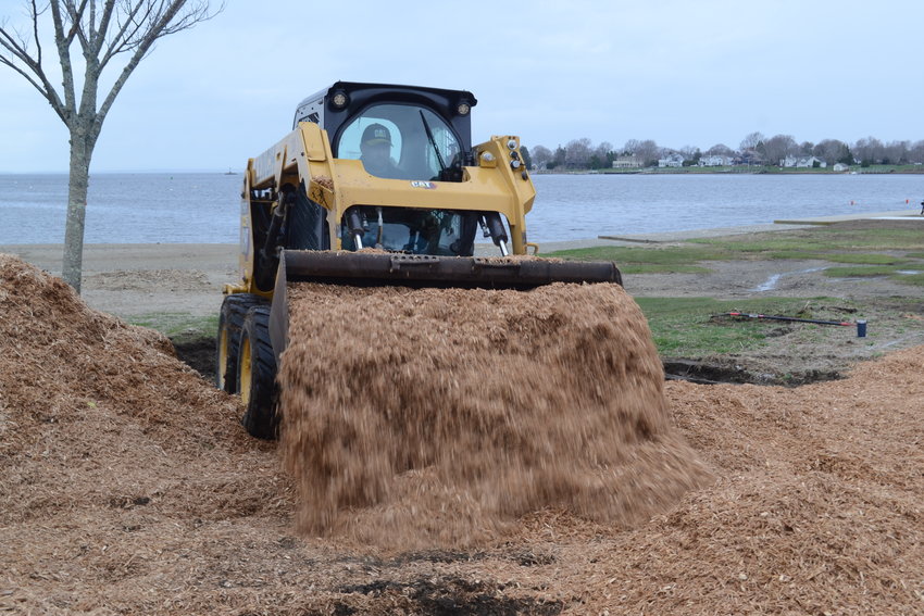 The use of a CAT was a major help in spreading the huge pile of mulch that was needed to cover the new playground at the Warren Town Beach. It was provided for use with the permission of J.H. Lynch &amp; Sons, Inc., where two of Thibaudeau&rsquo;s sons work. Operating the CAT is Byron Thibaudeau.