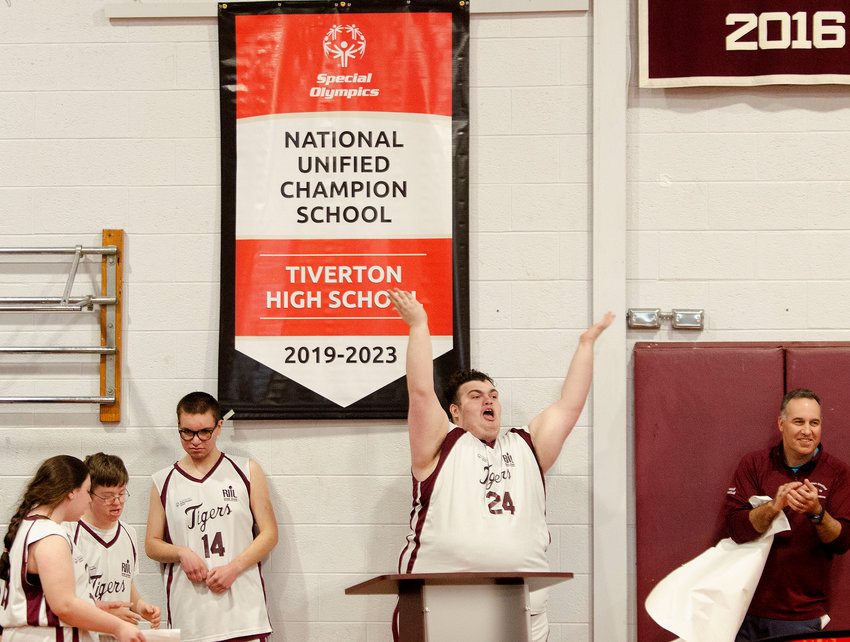 Aidan McCrosson (right) and coach Dave Landoch (right) and the team celebrate as they unveil their new sign saying that Tiverton is a national unifield champion High School.&nbsp;&nbsp;