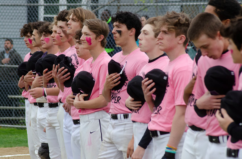Aidan Ramaglia (middle) and the Huskies take off their caps during the playing of the National Anthem before their Strike-Out Cancer game with Barrington at Guiteras Field on Friday afternoon.  The two teams used the game as a fund-raiser for the Jimmy Fund, collecting more than $5,000 in donations.