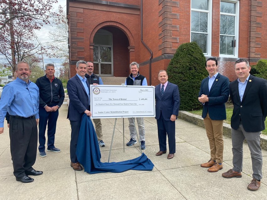 Town Administrator Steven Contente and Congressman David Cicilline flank a big check secured by Cicilline for the conversion of the old Walley School building. Also pictured: Council Chairman Nathan Calouro, Police Chief Kevin Lynch, Acting Director of Parks and Recreation Tim Shaw, Sen Wally Felag, Councilman Tim Sweeney, and Councilman Aaron Ley.
