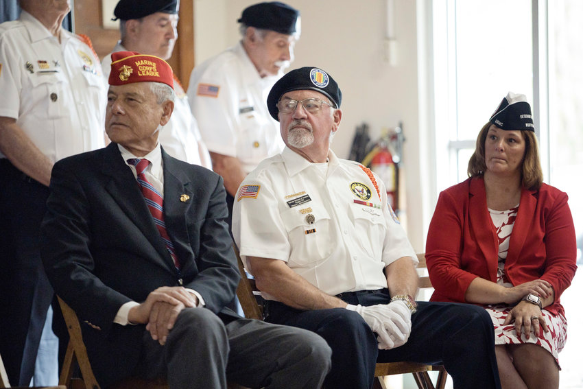 Veterans (from left) Paul Schmid III, Justin Latini and Carol Freitas listen to a speaker at last year's Memorial Day ceremony.