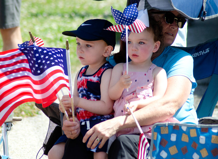 Emmett Mountain, 2, (left) and his twin sister Penelope sit with Patty Watson, while watching the Barrington Memorial Day Parade on Monday. Warm weather and sun-filled skies greeted parade-goers.