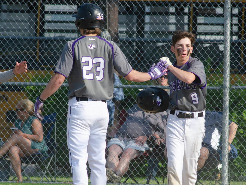 Brad Denson (left) celebrates with Ethan Santerre after the freshman scored a run in the second inning. The Huskies lead off hitter smashed three hits and drove in three runs.