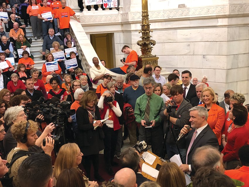 Advocates celebrated back in 2018, when then-Gov. Gina Raimondo signed an executive order making Rhode Island the first state to act on new gun policies since a gunman shot and killed 17 people at a Florida high school earlier that month. The event was attended by hundreds of people, including many students. Rep. Jason Knight (holding microphone) addressed the crowd in the Statehouse lobby at the time.