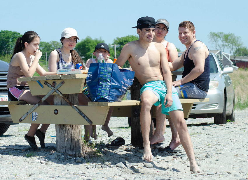 A family enjoys a pizza on the beach Sunday, during Fogland's opening weekend.