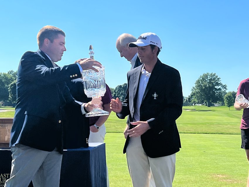 Tournament director Ben Tuthill hands the Northeast Amateur crystal championship trophy to back-to-back winner Dylan Menante.