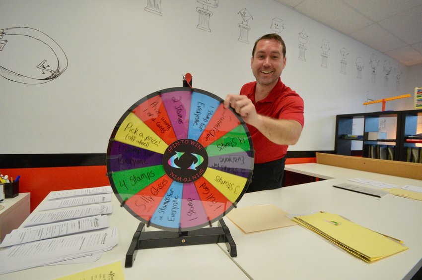 Ryan Costa, new owner of Mathnasium, spins the wheel of fortune which determines a prize for winners of math games.