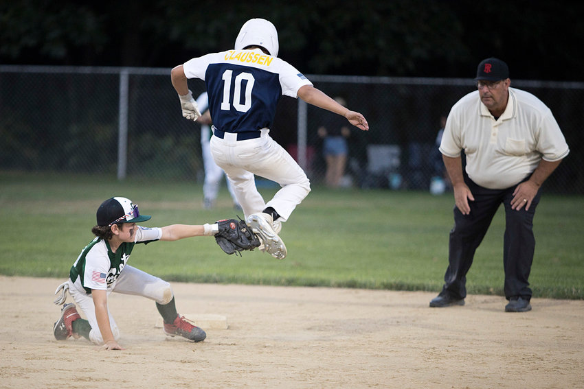Ben Claussen tries to avoid a tag by leaping over the second baseman's glove.