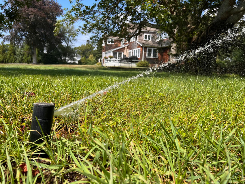 A sprinkler splashes water across a lawn in Barrington.