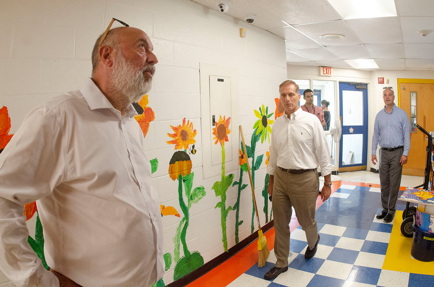 Joseph DaSilva, the coordinator for the state&rsquo;s school building authority, (left) takes a look at the ceiling tiles at Sowams School during a tour of the local elementary schools. Barrington Superintendent of Schools Michael Messore (middle) and other school officials stand nearby.