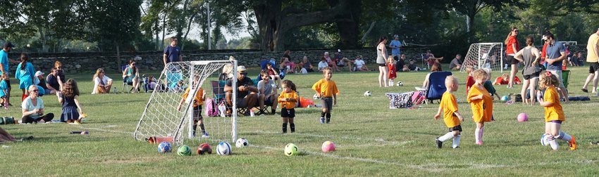 Children scamper around the special events field at the Gardner Seveney Sports Complex during the Portsmouth Youth Soccer Association&rsquo;s game night on July 19.