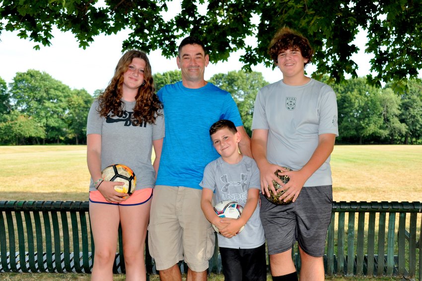 Warren Youth Soccer Association coach Toby Moran (center) is flanked by Emily, Philip and Matthew Moran. Toby, a Stage 4 lymphoma cancer survivor and bone marrow transplant recipient, enjoys coaching children in the sport he loves best.
